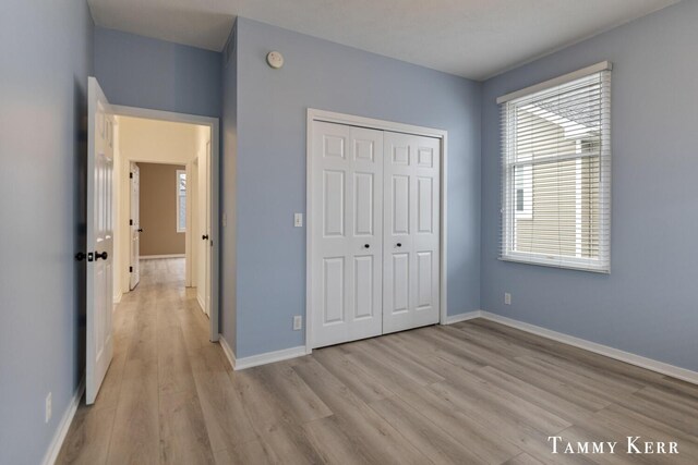 unfurnished bedroom featuring light wood-type flooring and a closet