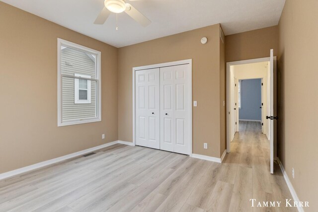 unfurnished bedroom featuring ceiling fan, light hardwood / wood-style floors, and a closet