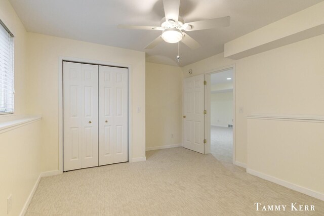 unfurnished bedroom with light carpet, a closet, and ceiling fan