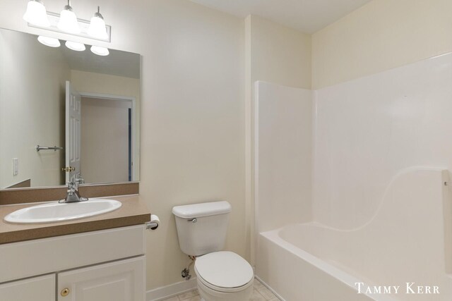 full bathroom with washtub / shower combination, vanity, toilet, and tile patterned flooring