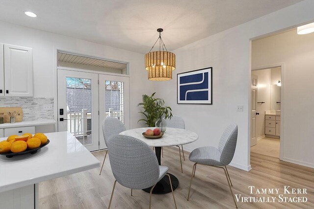 dining space featuring a notable chandelier and light wood-type flooring