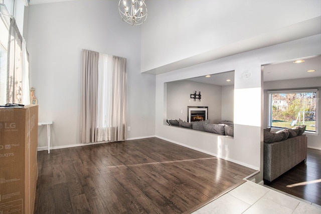 unfurnished living room with dark wood-type flooring and an inviting chandelier