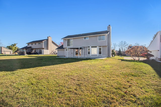 rear view of house with a patio area and a yard