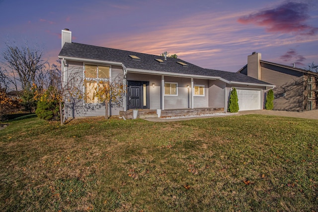 ranch-style house featuring a lawn and a garage