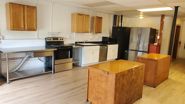2639 S 3rd St, Niles, MI 49120 - kitchen with a paneled ceiling, a center island, sink, light wood-type flooring, and stainless steel appliances