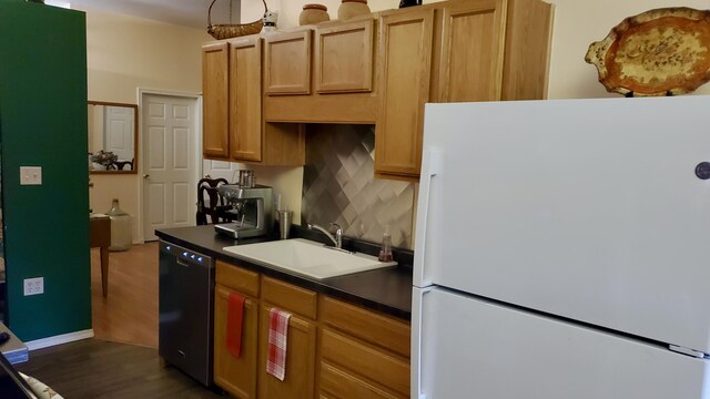 2639 S 3rd St, Niles, MI 49120 - kitchen with dishwasher, sink, dark hardwood / wood-style floors, backsplash, and white fridge