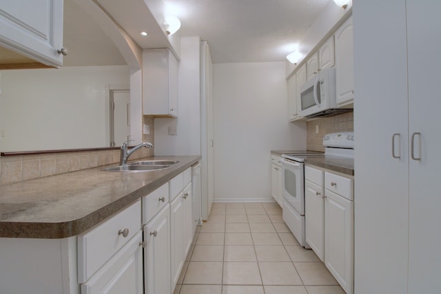 kitchen featuring tasteful backsplash, white appliances, sink, white cabinets, and light tile patterned flooring