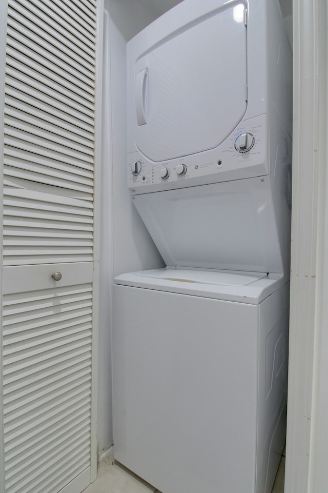 clothes washing area featuring stacked washer and clothes dryer