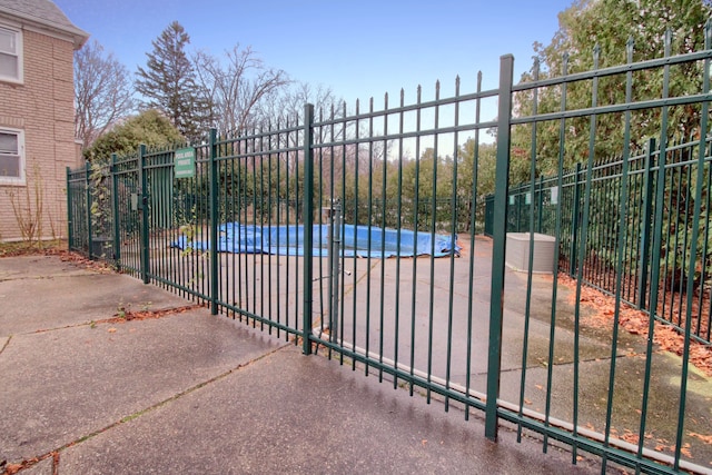 view of gate featuring a covered pool