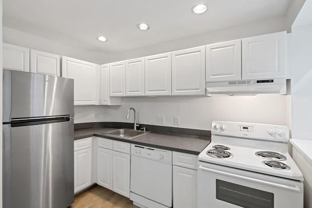 kitchen with white cabinets, white appliances, light hardwood / wood-style flooring, and sink