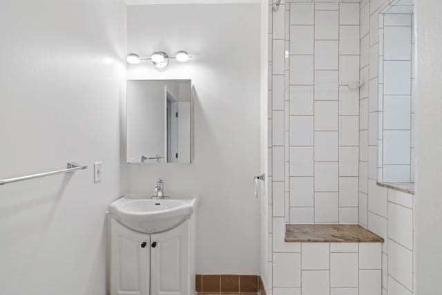 bathroom with vanity and tiled shower