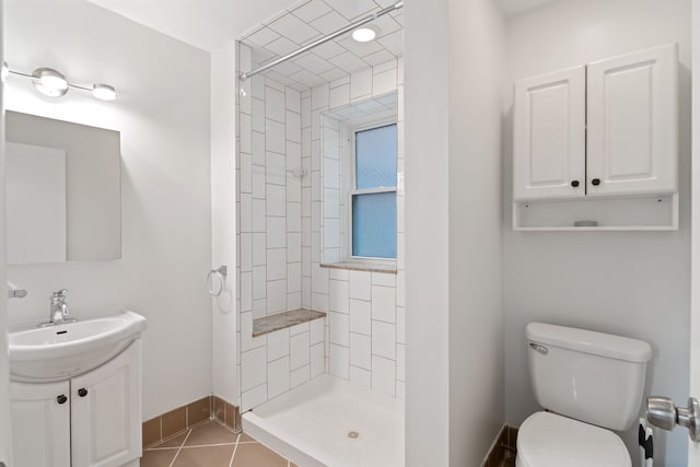 bathroom featuring tile patterned floors, vanity, toilet, and tiled shower