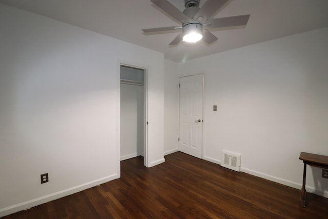 unfurnished bedroom featuring ceiling fan and dark hardwood / wood-style flooring