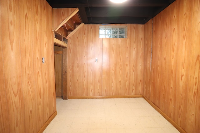 basement featuring wood walls