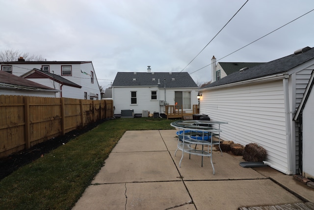 rear view of property featuring central AC unit, a yard, and a patio