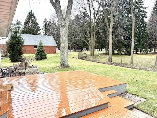 wooden terrace featuring a lawn