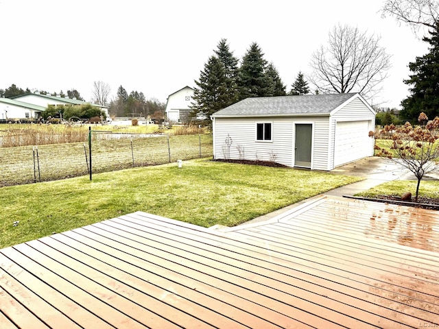 wooden deck featuring a lawn, a garage, and an outbuilding