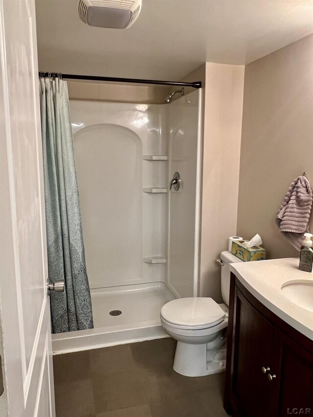 bathroom with walk in shower, vanity, and toilet