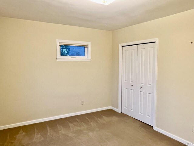 unfurnished bedroom featuring carpet and a closet