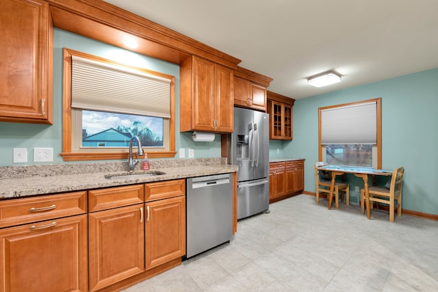 kitchen featuring light stone counters, sink, and appliances with stainless steel finishes