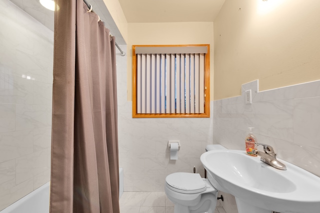 full bathroom with toilet, tile walls, shower / bath combo with shower curtain, and sink