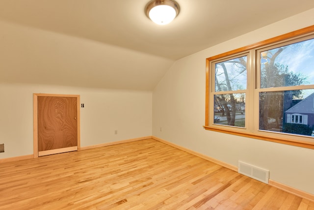 bonus room with light wood-type flooring and lofted ceiling