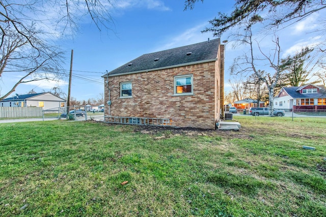 view of side of home with a yard