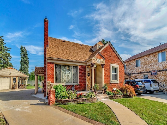 view of front facade featuring an outbuilding, a front lawn, and a garage