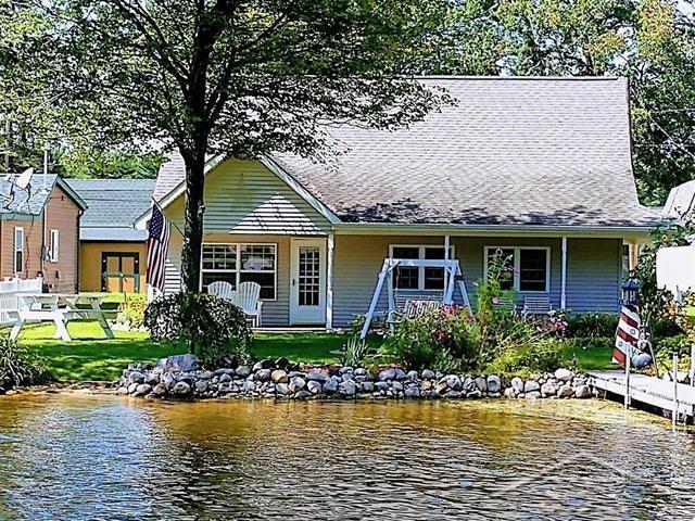 rear view of property with a water view and a yard