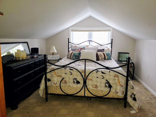 carpeted bedroom with baseboards and vaulted ceiling