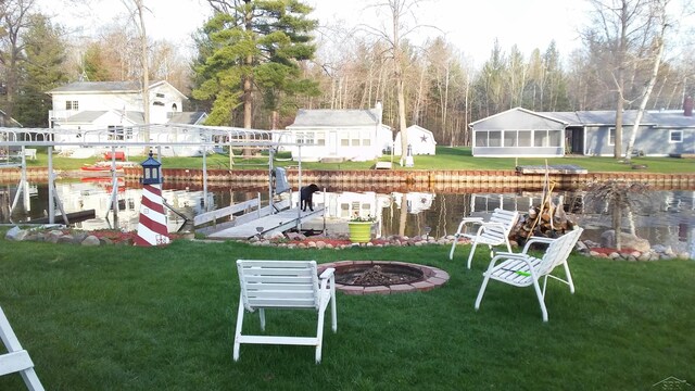 view of yard with a boat dock and a sunroom