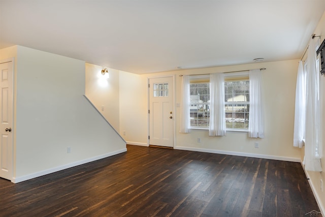 foyer featuring baseboards and wood finished floors