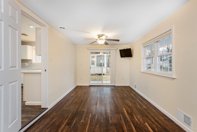 spare room with visible vents, ceiling fan, baseboards, and wood finished floors