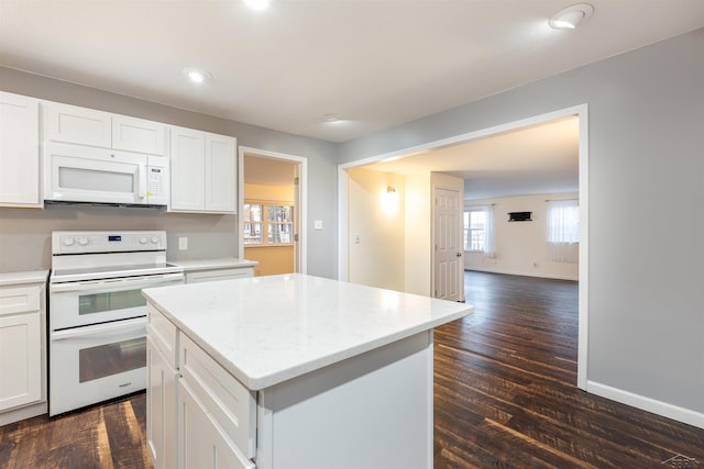 kitchen with a center island, white appliances, white cabinetry, and dark wood-style flooring