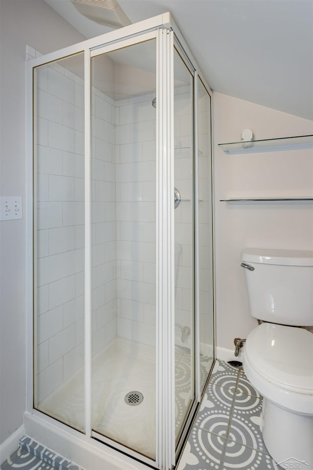 full bathroom featuring baseboards, lofted ceiling, a shower stall, tile patterned floors, and toilet