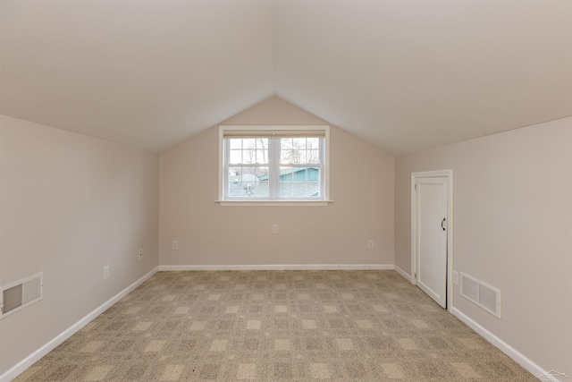 bonus room featuring visible vents, lofted ceiling, light colored carpet, and baseboards