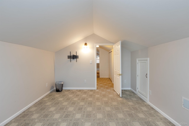 bonus room with baseboards, lofted ceiling, light colored carpet, and visible vents