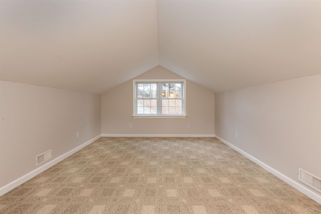 bonus room with lofted ceiling, baseboards, and visible vents