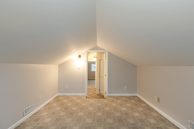 bonus room with light carpet, visible vents, baseboards, and lofted ceiling