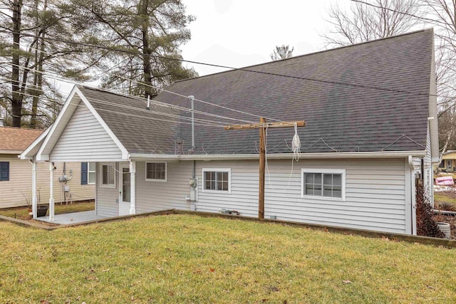 back of property with a lawn and a shingled roof