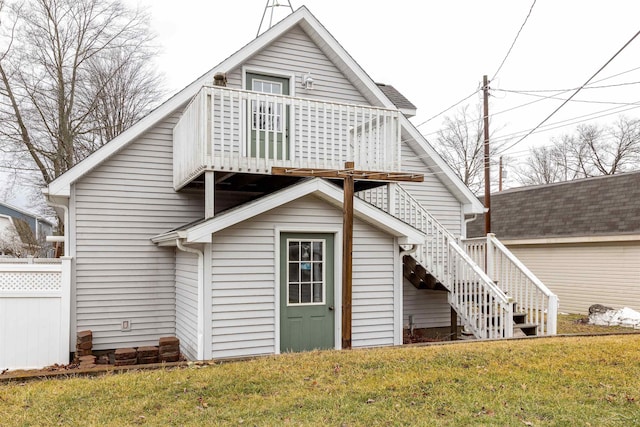 rear view of house featuring stairway and a lawn