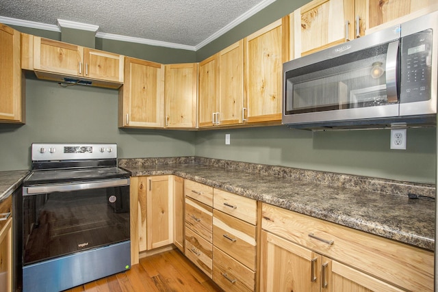 kitchen with light wood-type flooring, dark stone counters, a textured ceiling, stainless steel appliances, and crown molding