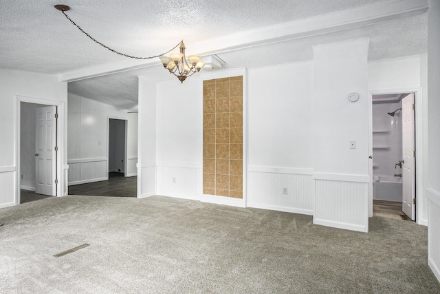 spare room with dark colored carpet, a textured ceiling, lofted ceiling, and a notable chandelier