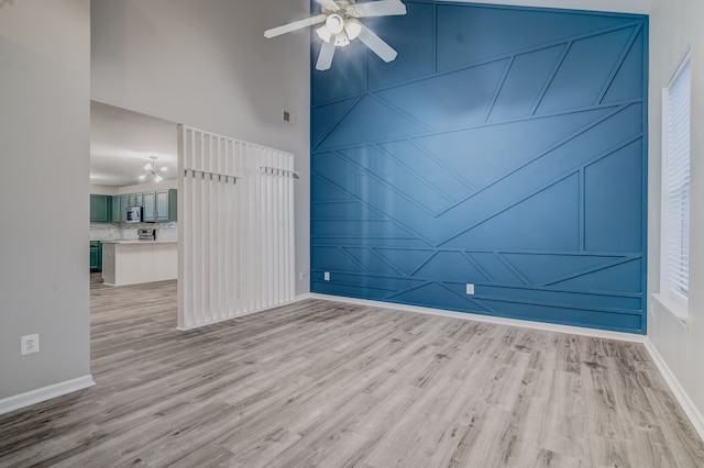 spare room with light wood-type flooring and ceiling fan