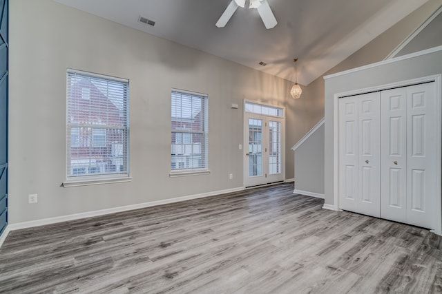 foyer entrance with french doors, light hardwood / wood-style floors, vaulted ceiling, and ceiling fan