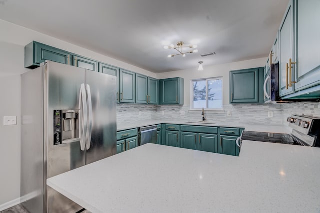 kitchen featuring tasteful backsplash, kitchen peninsula, sink, and appliances with stainless steel finishes