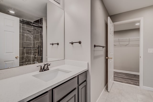 bathroom with a shower with door and vanity