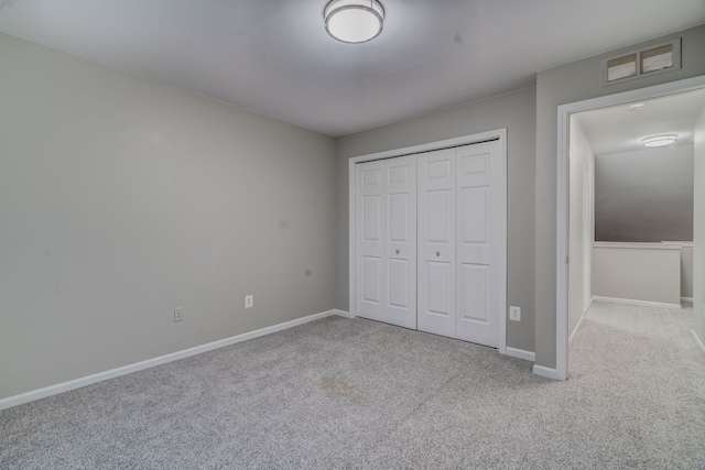 unfurnished bedroom featuring light colored carpet and a closet