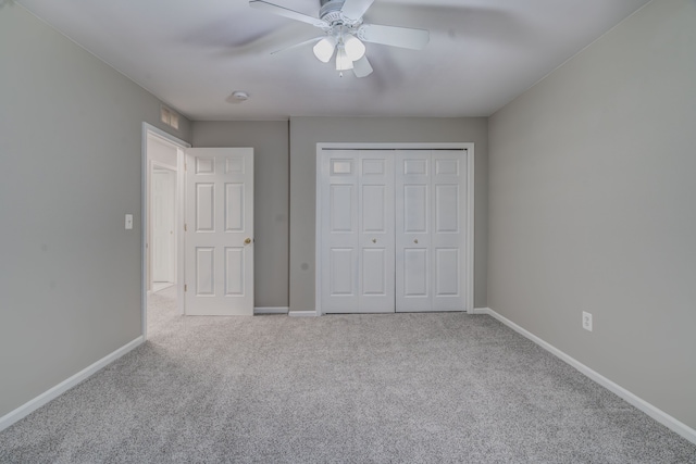 unfurnished bedroom with ceiling fan, light carpet, and a closet