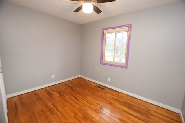 empty room with ceiling fan and hardwood / wood-style flooring